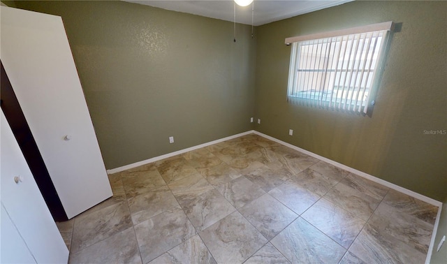 tiled empty room featuring ceiling fan