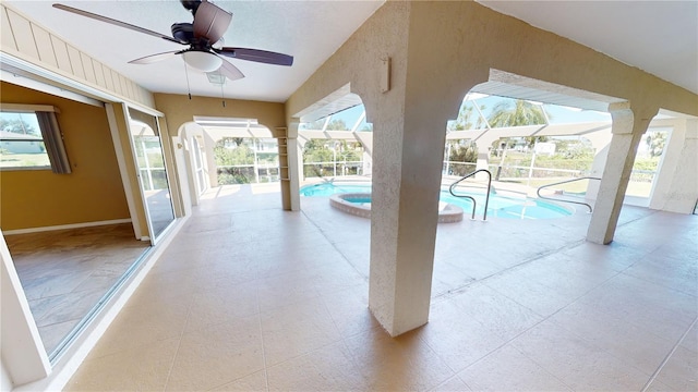 unfurnished sunroom with ceiling fan