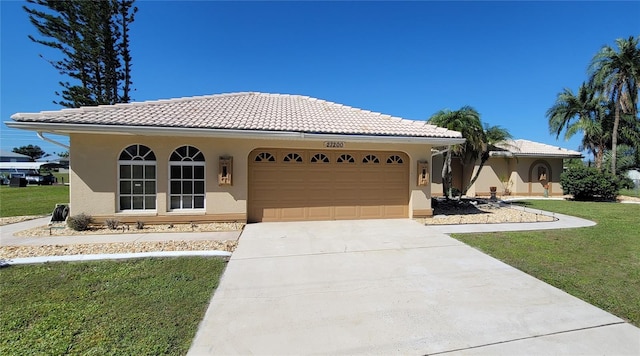 mediterranean / spanish house featuring a front lawn and a garage