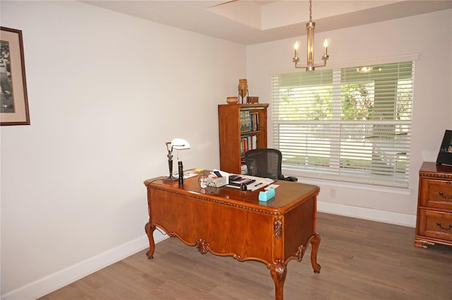 office with dark hardwood / wood-style floors and an inviting chandelier