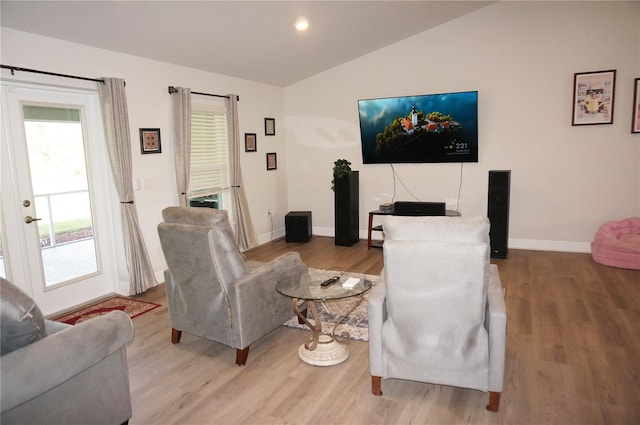 living room featuring vaulted ceiling, light hardwood / wood-style floors, and french doors