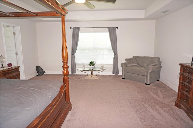 carpeted bedroom with a tray ceiling and ceiling fan