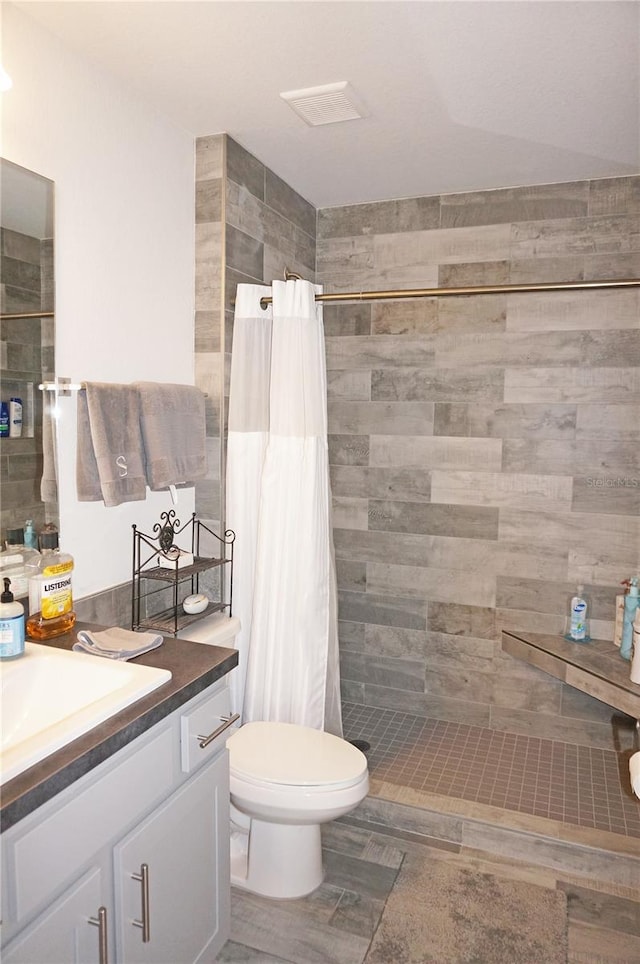 bathroom with vanity, a shower with shower curtain, and toilet