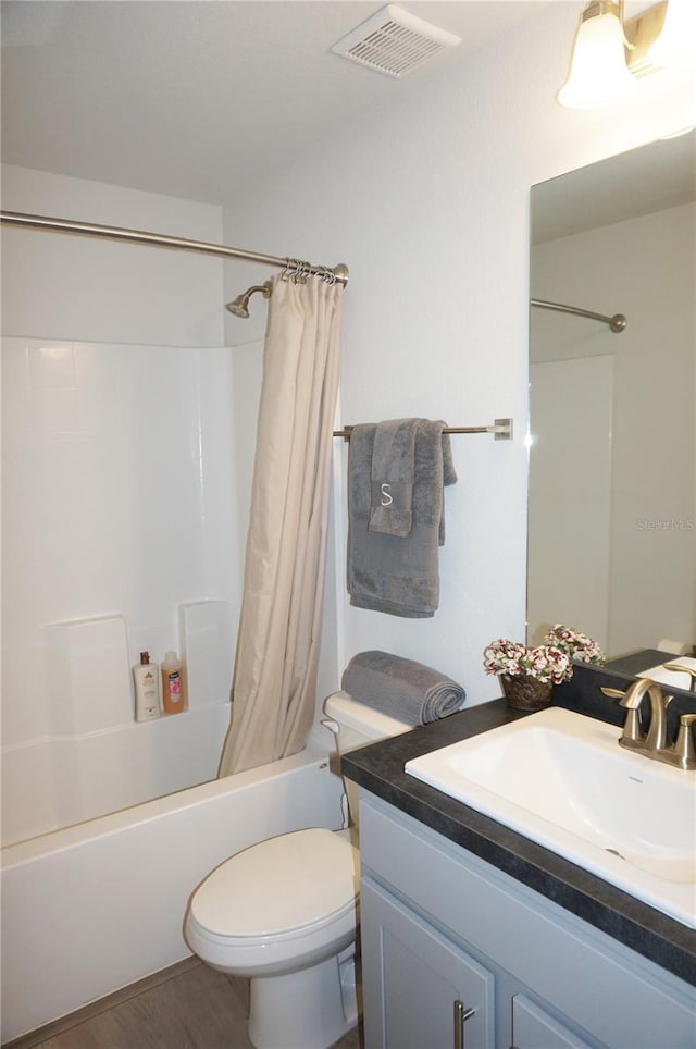 full bathroom with shower / bath combination with curtain, toilet, and vanity