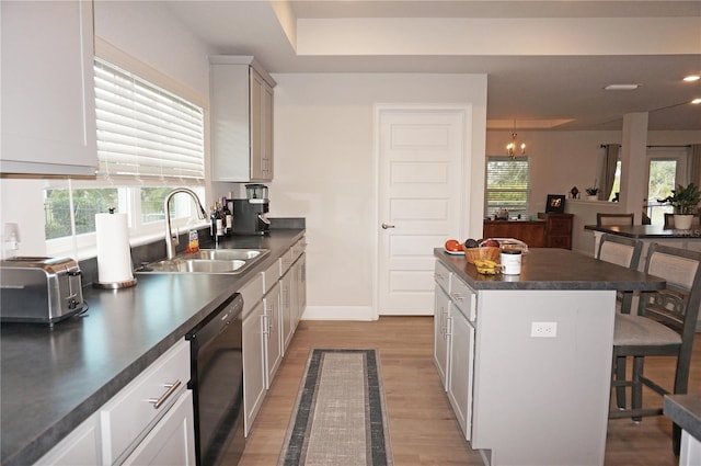 kitchen with a wealth of natural light, a chandelier, dishwasher, and sink