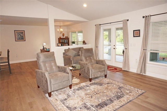 interior space featuring french doors, hardwood / wood-style floors, a chandelier, and lofted ceiling