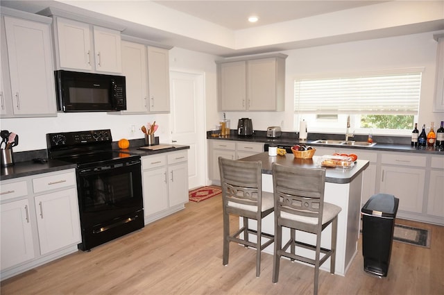 kitchen featuring white cabinets, light hardwood / wood-style floors, black appliances, and sink