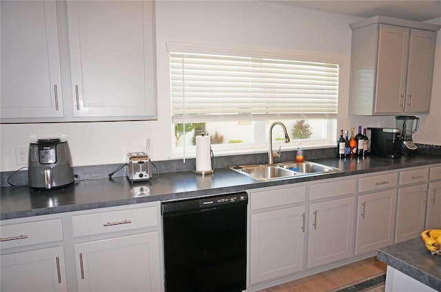 kitchen with black dishwasher, light wood-type flooring, and sink