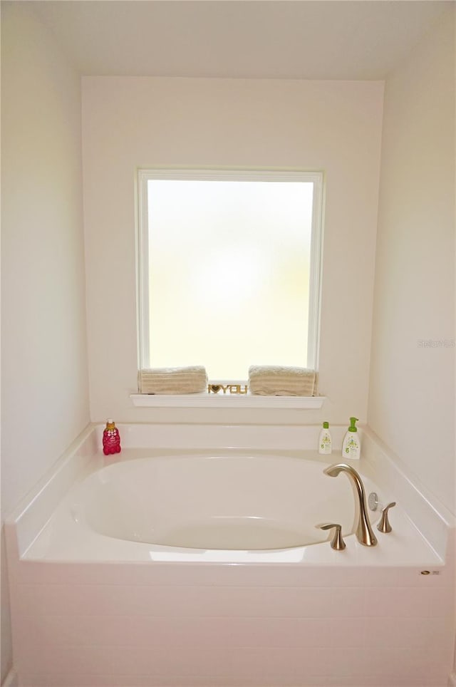 bathroom with a bath and a healthy amount of sunlight