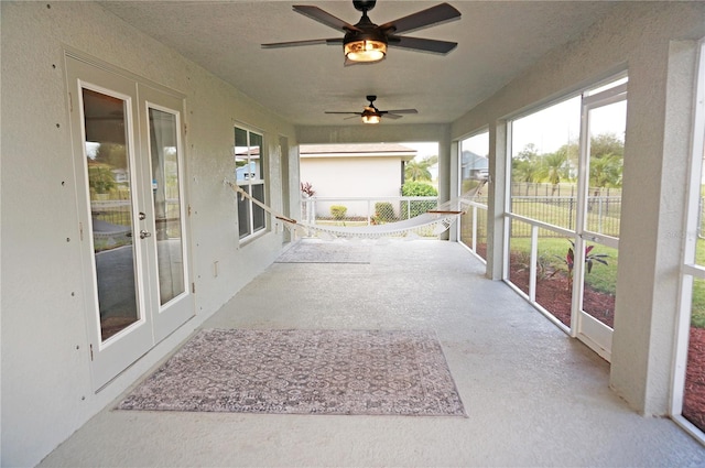 unfurnished sunroom with ceiling fan and french doors