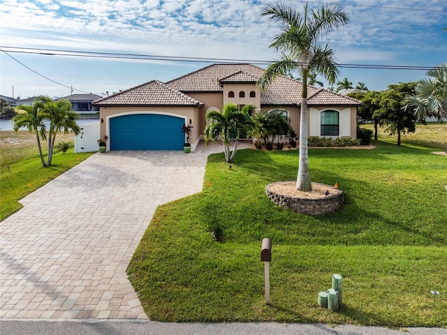 mediterranean / spanish home with a front lawn and a garage