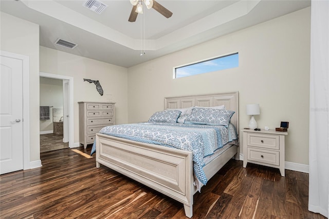 bedroom with a raised ceiling, ceiling fan, and dark hardwood / wood-style flooring