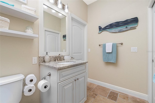 bathroom with tile floors, vanity with extensive cabinet space, and toilet