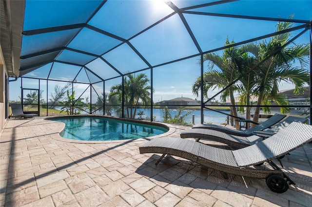 view of pool with a water view, a patio area, and glass enclosure