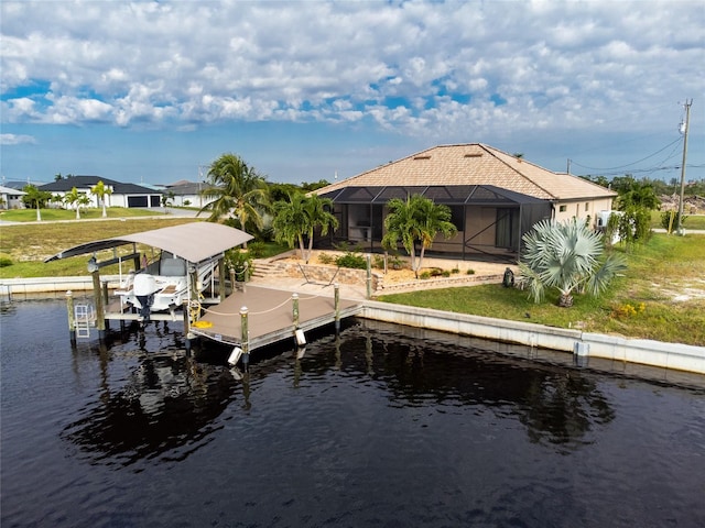 dock area with a lawn, glass enclosure, and a water view