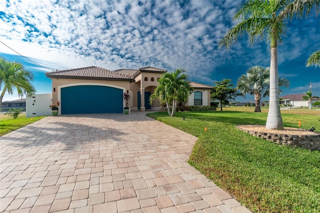 mediterranean / spanish house featuring a front yard and a garage