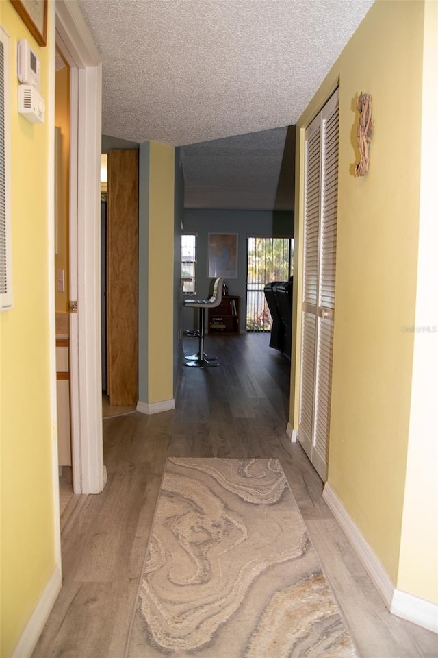 corridor featuring hardwood / wood-style flooring and a textured ceiling