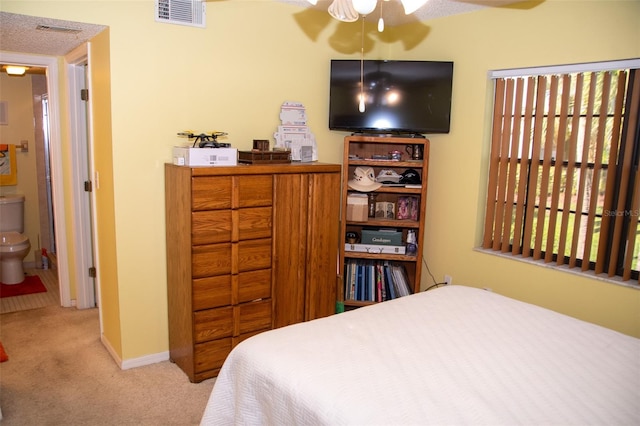 bedroom with light colored carpet and ensuite bathroom