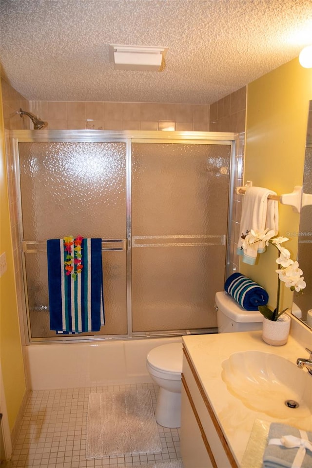 full bathroom with tile patterned floors, toilet, a textured ceiling, vanity, and enclosed tub / shower combo