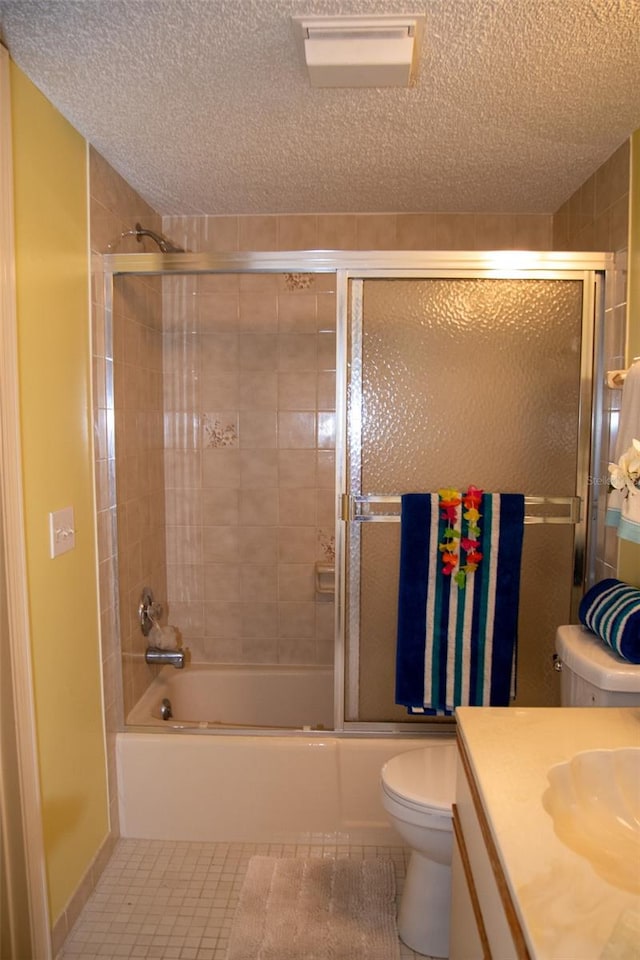 full bathroom featuring tile patterned flooring, enclosed tub / shower combo, vanity, toilet, and a textured ceiling