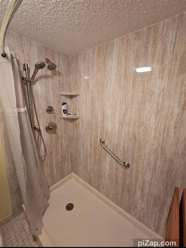 bathroom with tile patterned flooring, a textured ceiling, and a shower with shower curtain