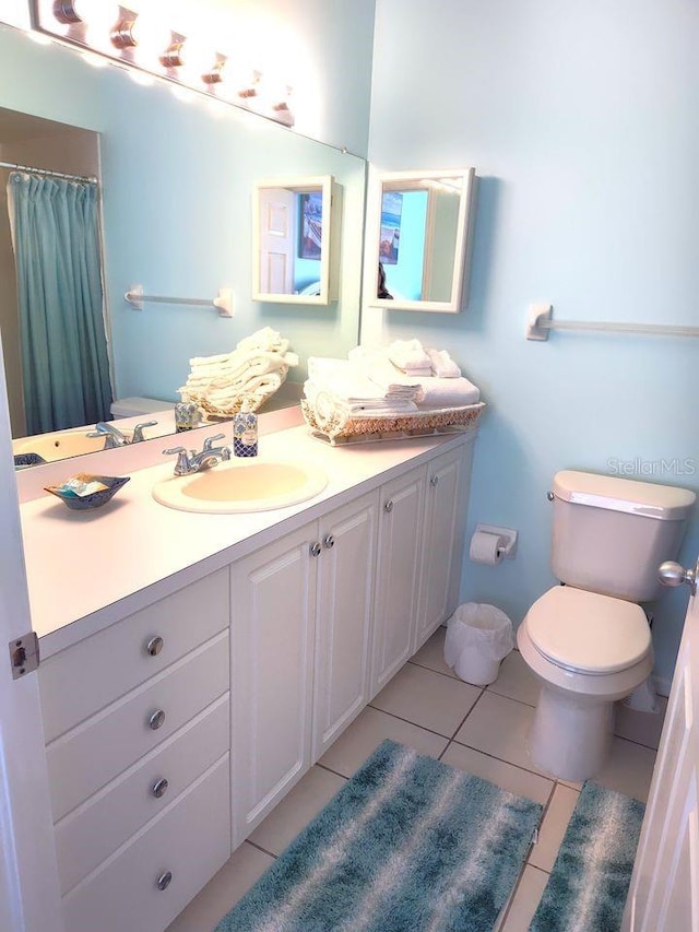 bathroom featuring toilet, tile floors, and vanity