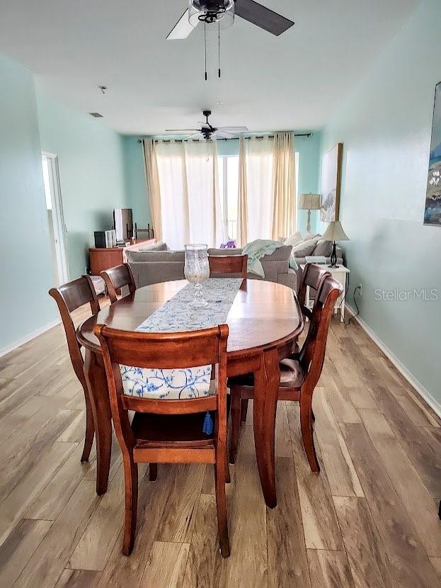 dining space featuring ceiling fan and light wood-type flooring