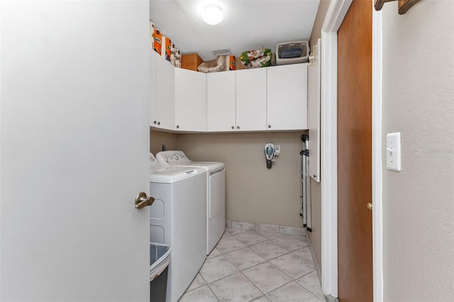 laundry area featuring cabinets, independent washer and dryer, and light tile floors