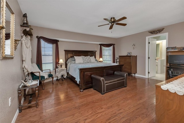 bedroom featuring hardwood / wood-style floors, ensuite bath, and ceiling fan