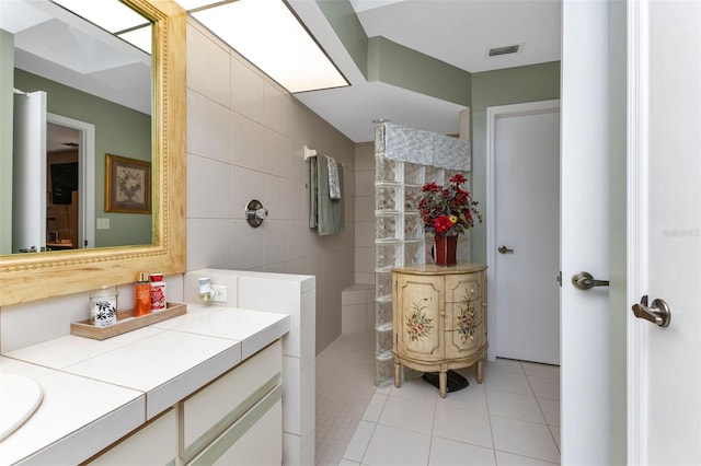 bathroom featuring tile walls, vanity, and tile flooring