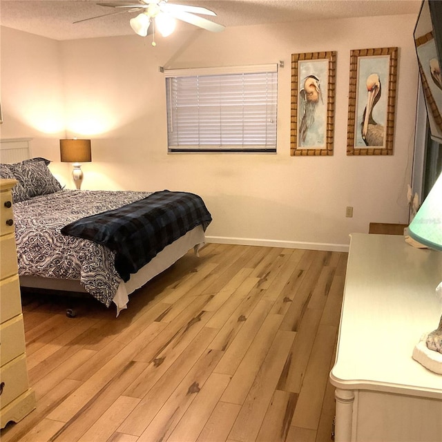 bedroom featuring a textured ceiling, ceiling fan, and light hardwood / wood-style floors