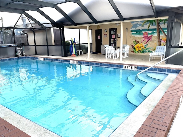 view of swimming pool featuring glass enclosure and a patio