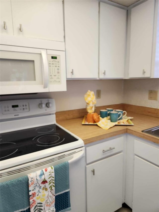 kitchen featuring white cabinetry and white appliances