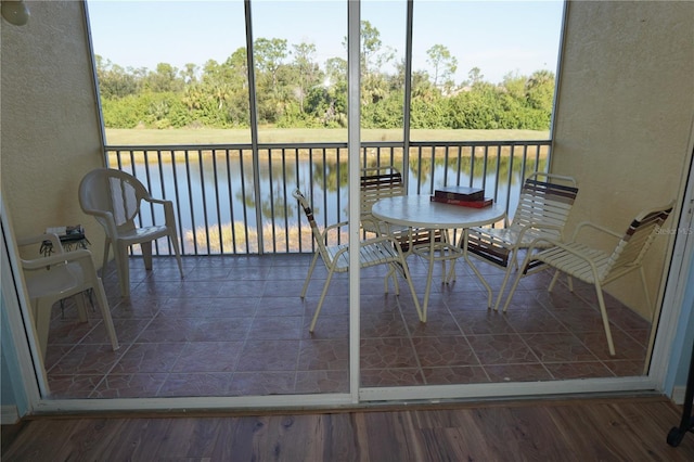 unfurnished sunroom featuring a water view