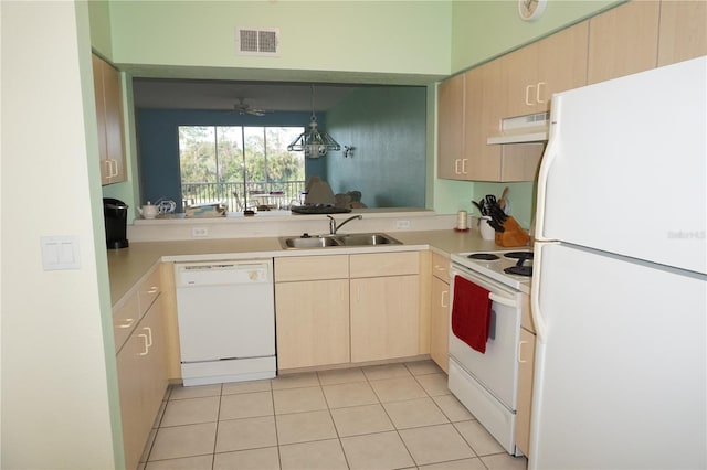 kitchen with light brown cabinets, light tile flooring, white appliances, hanging light fixtures, and sink