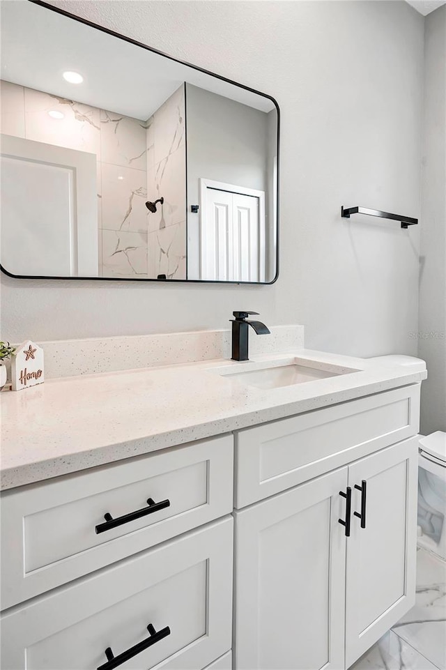 bathroom featuring toilet, vanity, and walk in shower