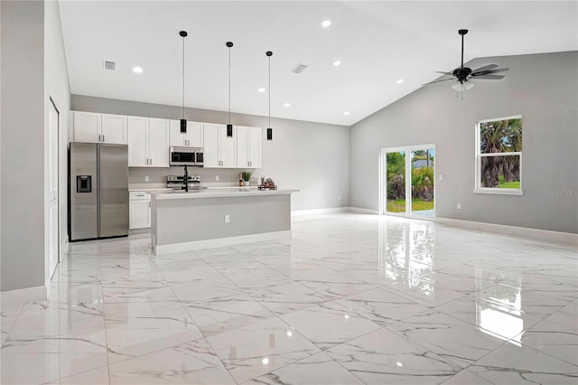 kitchen featuring high vaulted ceiling, white cabinetry, stainless steel appliances, and pendant lighting