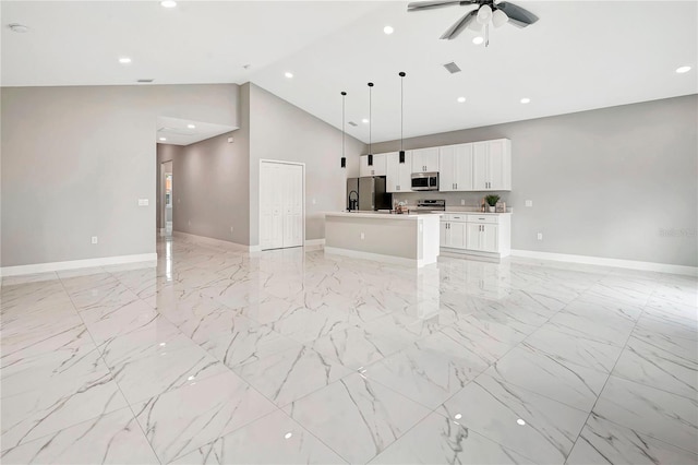 unfurnished living room featuring ceiling fan and high vaulted ceiling