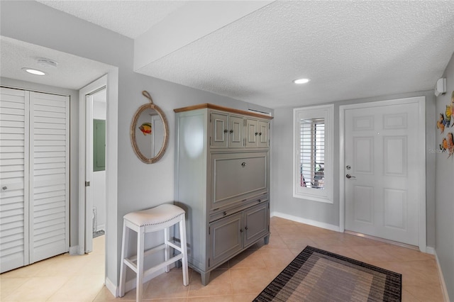 tiled foyer entrance with a textured ceiling