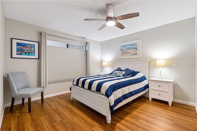 bedroom with ceiling fan, light hardwood / wood-style flooring, and a textured ceiling