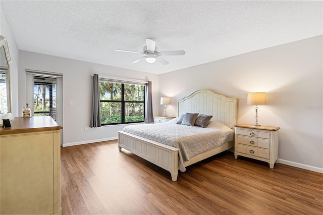 bedroom with ceiling fan, a textured ceiling, and hardwood / wood-style flooring