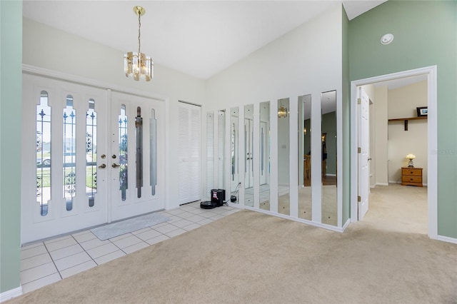 carpeted foyer entrance with vaulted ceiling and a notable chandelier