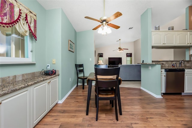 dining room with ceiling fan, hardwood / wood-style floors, and vaulted ceiling