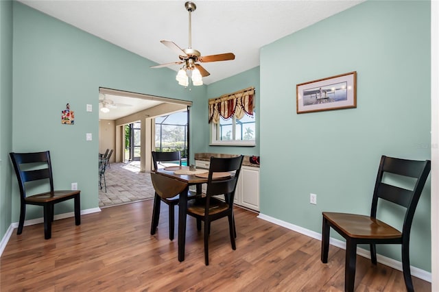 dining area with vaulted ceiling, ceiling fan, and hardwood / wood-style flooring