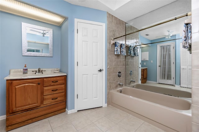 bathroom featuring tiled shower / bath combo, vanity, tile patterned floors, ceiling fan, and a textured ceiling