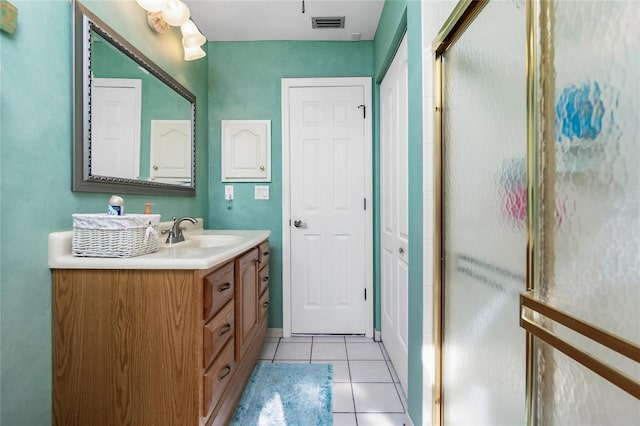 bathroom with tile patterned floors, vanity, and a shower with shower door