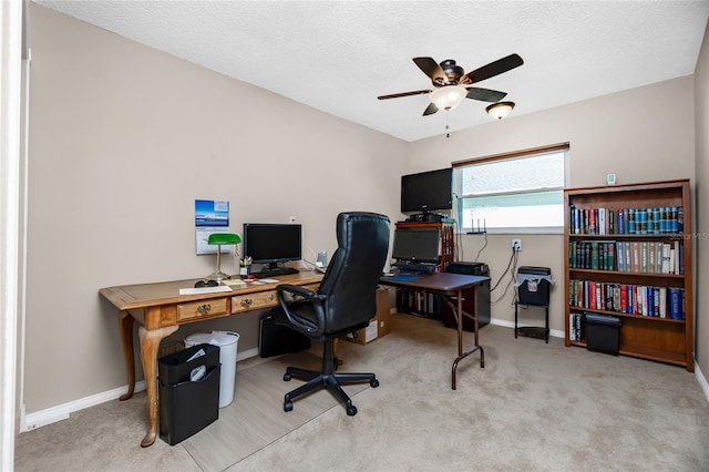 carpeted home office featuring ceiling fan and a textured ceiling