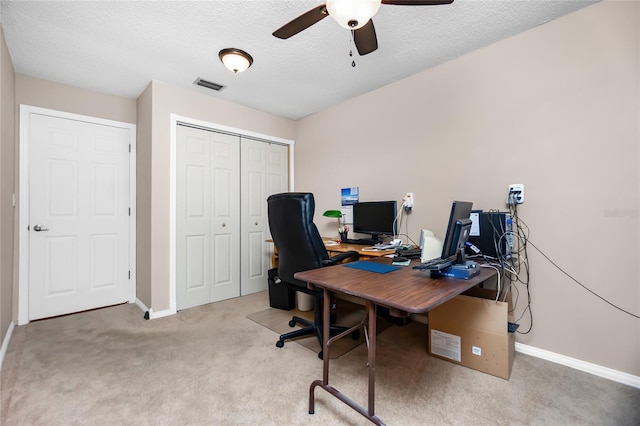 office with a textured ceiling, ceiling fan, and light colored carpet