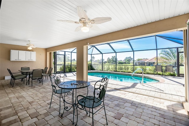 view of swimming pool featuring a lanai, a patio area, and ceiling fan