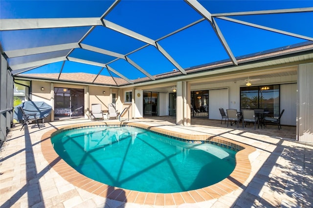 view of swimming pool with area for grilling, ceiling fan, glass enclosure, and a patio